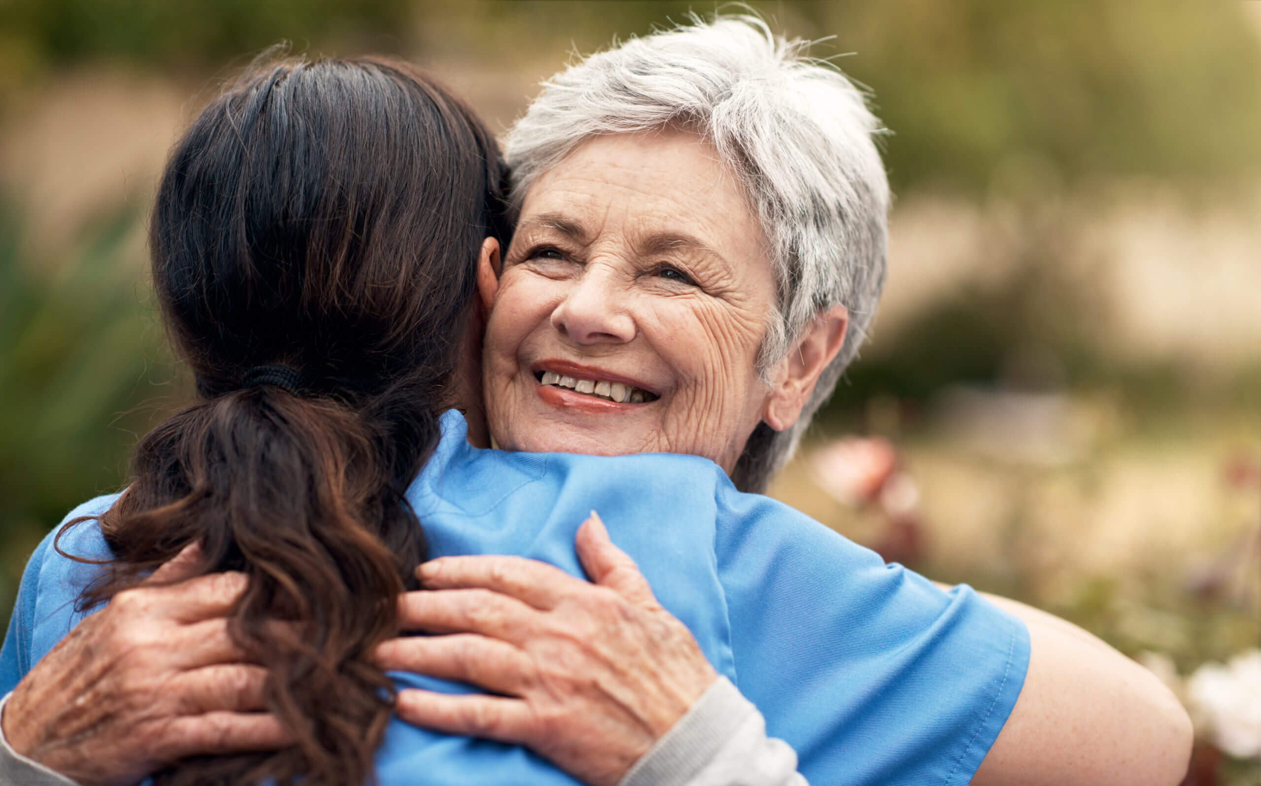 caregiver assisting senior man get out of bed