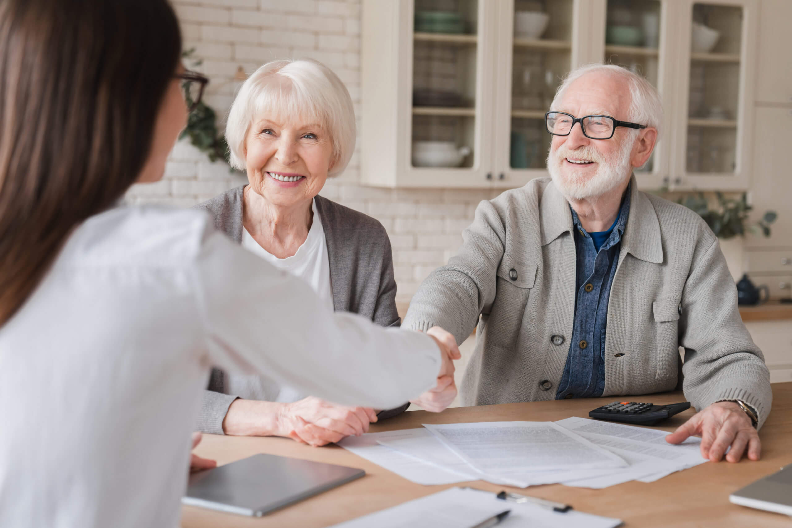 senior caregiver shaking a patient's hand 