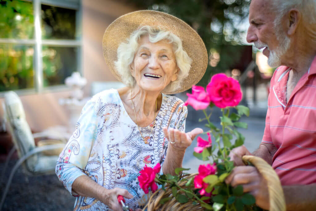 senior man and woman holding a rose 